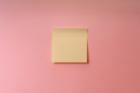 Centered single blank yellow stick note on pink backgroundの写真素材
