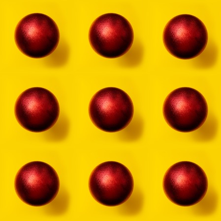 Red Christmas ball pattern on yellow background horizontal linesの写真素材