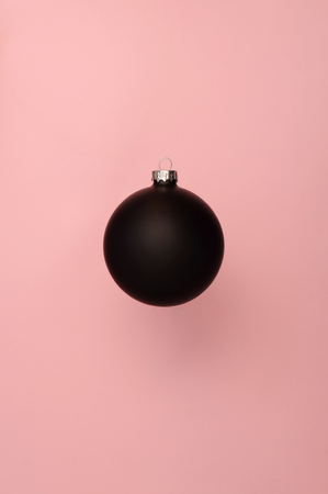 Black Christmas ball on the plane pink backgroundの写真素材