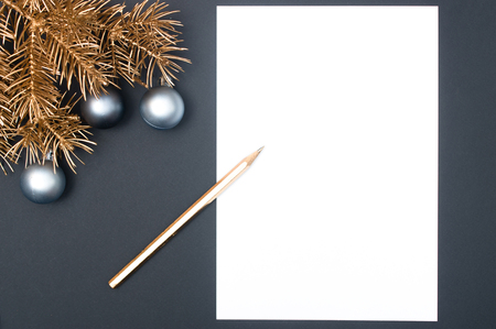 Golden Christmas tree branches decorated with silver baubles and golden pencil with copy space isolatedの写真素材