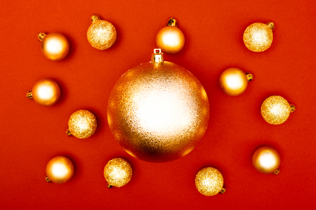 Multiple Christmas baubles surrounded big golden ball in the center of the red backgroundの写真素材