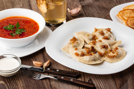 Traditional ukrainian dish vareniki and borscht served with greaves and sour cream. Close up view of...
