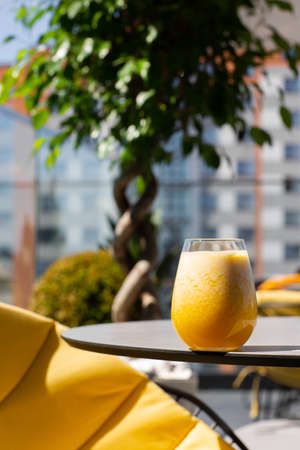 Glass of yellow banana, orange , mango smoothies or juice fruit isolated on bright background. Overhead view, copy space. Advertising for cafe menuの写真素材