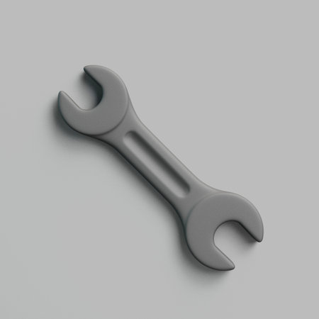 Realistic 3D metal wrench tool lying diagonally on gray surfaceの写真素材