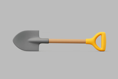 3D render of shovel with yellow handle and gray blade lying flat on neutral gray surfaceの写真素材