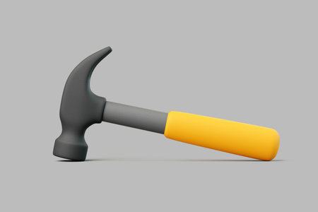 Minimal 3D hammer with yellow handle and gray metal head lying on gray surfaceの写真素材