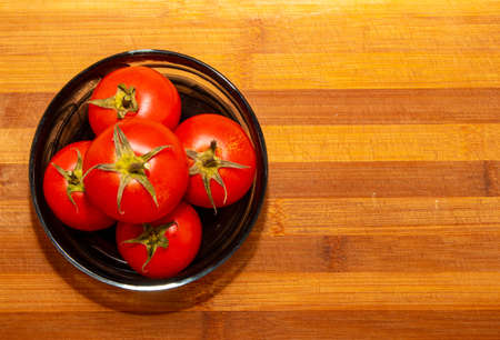 Red fresh tomatoes on a wooden board.flat layの写真素材