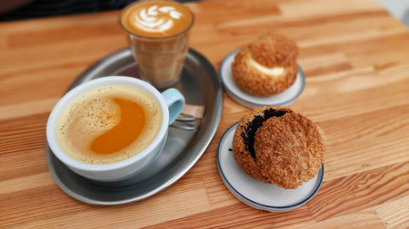 Delicious breakfast in a coffee shop. Fragrant mandarin tea and latte with cookies allow you to recharge your batteries for the whole winter morning and feel the warmth of the tropics. Talking to a nice person at this table will be productive.の写真素材