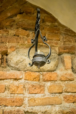 old candlestick against the red brick wall of the castle in Belarus 16th centuryの写真素材