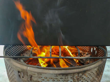 firewood burning in a fire warming up a barbecueの写真素材