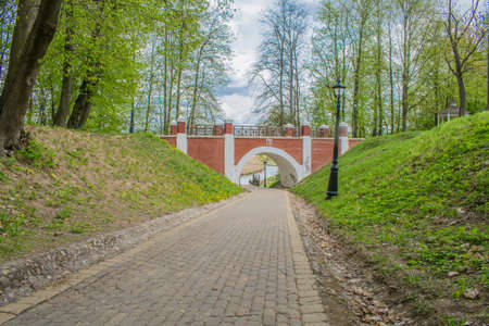 paths in a spring park landscape against a blue sky and green treesの写真素材