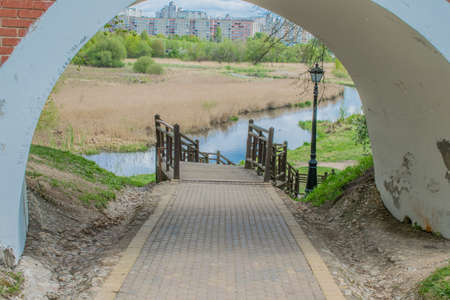 paths in a spring park landscape against a blue sky and green treesの写真素材