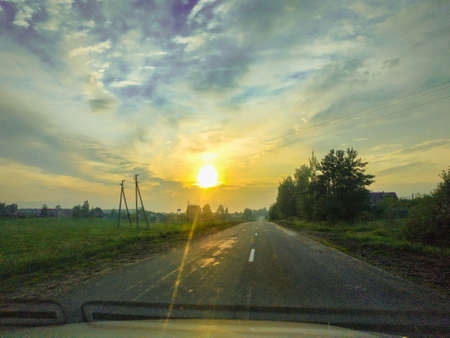evening sunset on the road through the carの写真素材