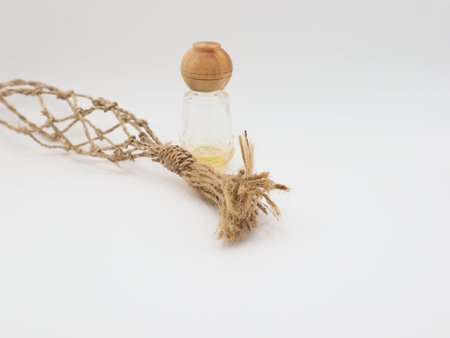 Essential oil in a glass bottle with a rope on a white backgroundの写真素材