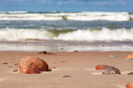 Stones on the beach closeup on sea background.の写真素材