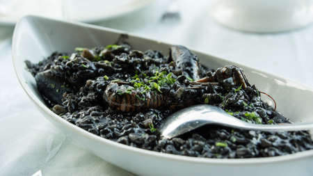A plate of black risotto with seafoodの写真素材