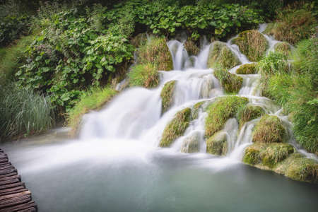 Small peaceful cascade waterfall with silky waterの写真素材