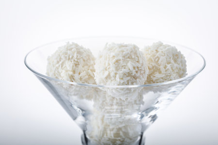 truffles white chocolate covered with coconut flakes on white backgroundの写真素材