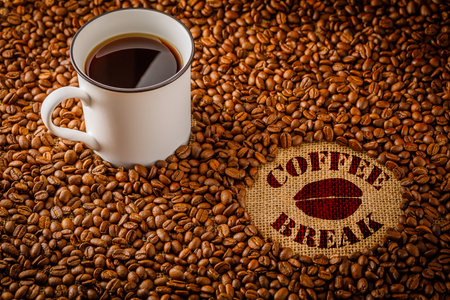 white cup of coffee on the background with coffee beansの写真素材
