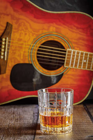 still life with whiskey and acoustic guitarの写真素材