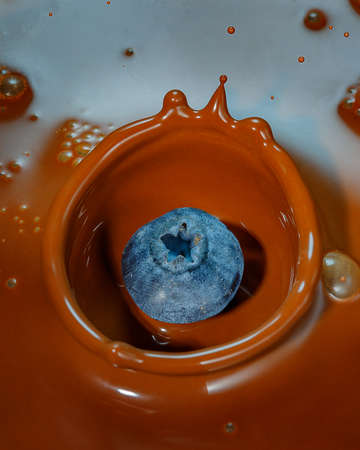 blueberry dropping into chocolate, splash of chocolateの写真素材