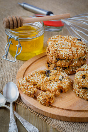 oatmeal cookies with raisins and sesame, honey in the jarの写真素材