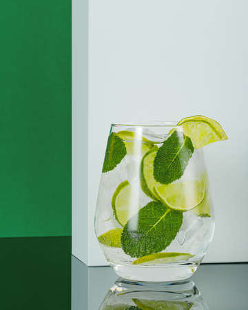 glass of tasty refreshing cocktail on color backgroundの写真素材