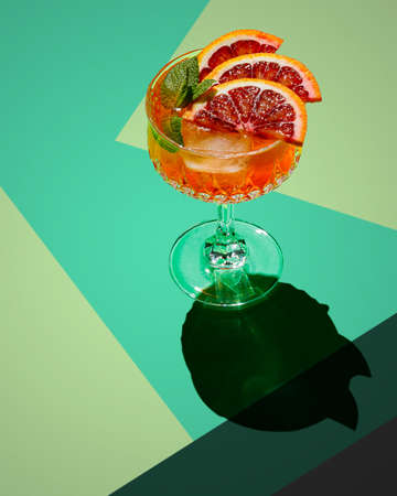 glass of cocktail with red blood orange on color backgroundの写真素材