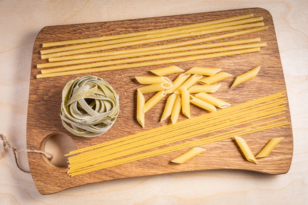 background of traditional italian uncooked pasta in the kitchenの写真素材
