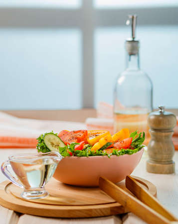 fresh vegetable salad with tomatoes and cucumber on wooden backgroundの写真素材