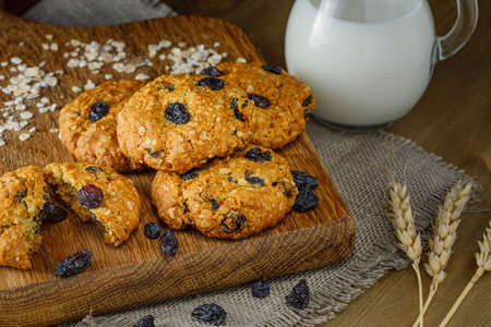 Fresh baked homemade oatmeal cookies with raisins and sunflower seeds on wooden backgroundの写真素材