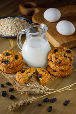 Fresh baked homemade oatmeal cookies with raisins and sunflower seeds on wooden backgroundの写真素材