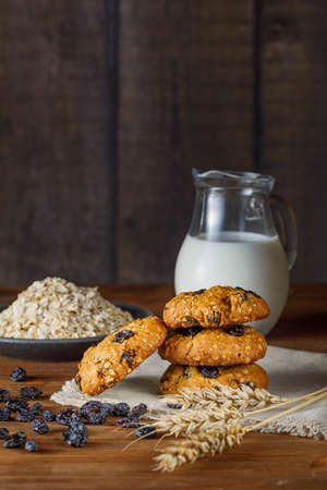Fresh baked homemade oatmeal cookies with raisins and sunflower seeds on wooden backgroundの写真素材