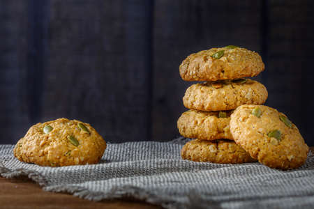 Fresh baked homemade oatmeal cookies with raisins and sunflower seeds on wooden backgroundの写真素材