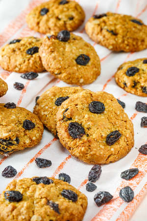 Fresh baked homemade oatmeal cookies with raisins and sunflower seeds on wooden backgroundの写真素材