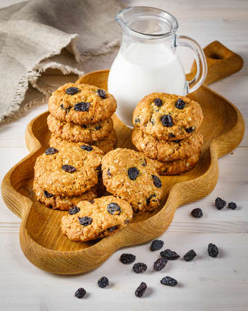 Fresh baked homemade oatmeal cookies with raisins and sunflower seeds on wooden backgroundの写真素材