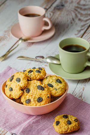 Fresh baked homemade oatmeal cookies with raisins and sunflower seeds on wooden backgroundの写真素材