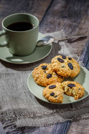 Fresh baked homemade oatmeal cookies with raisins and sunflower seeds on wooden backgroundの写真素材