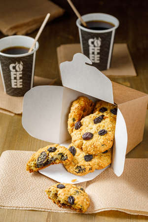 Fresh baked homemade oatmeal cookies with raisins and sunflower seeds on wooden backgroundの写真素材