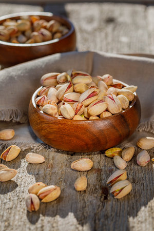 pistachio in shell nuts in bowl on wooden table background