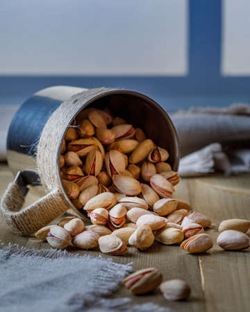 pistachio in shell nuts in bowl on wooden table backgroundの写真素材