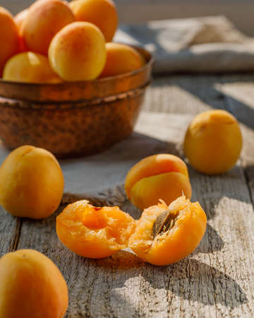 fresh ripe apricots in a basket on a wooden tableの写真素材