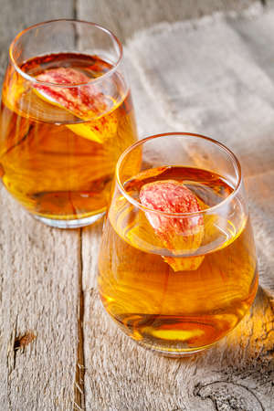 glass of apple juice and sliced apples on a tableの写真素材