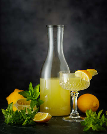 still life with glass of lemonade, lemons and mint, low key photographyの写真素材