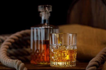 Glass and bottle of whiskey on rustic backgroundの写真素材