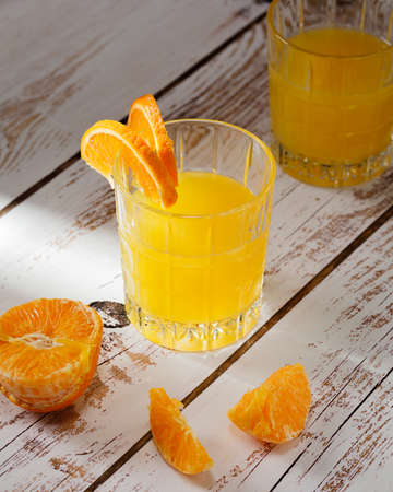 glass of fresh citrus juice on wooden backgroundの写真素材