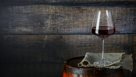 Still life with glass of red wine on wooden background, copy space