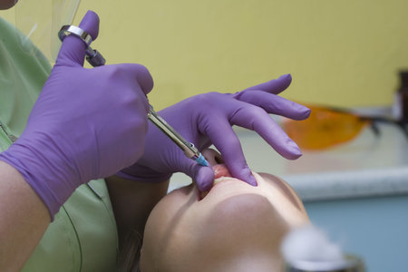 Young female patient takes a dental attendance in the dentist's office.