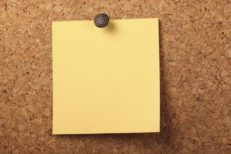 Blank Yellow textured notebook paper Pinned to the cork board.