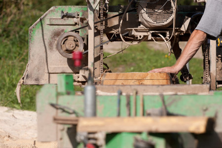 A man cutting timber on a portable sawmillの写真素材